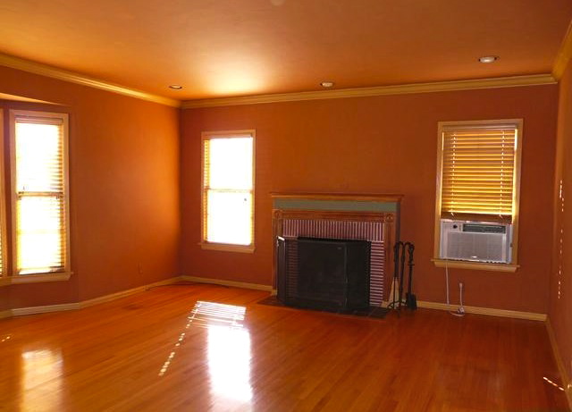 Living room with original wood floors, double hung windows and fireplace