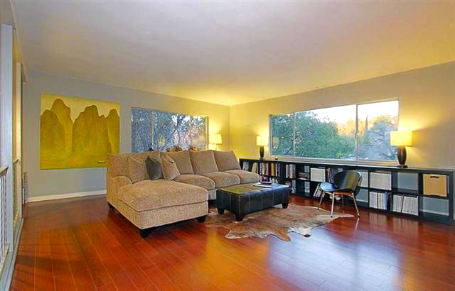 Living room with hardwood floors and treetop views