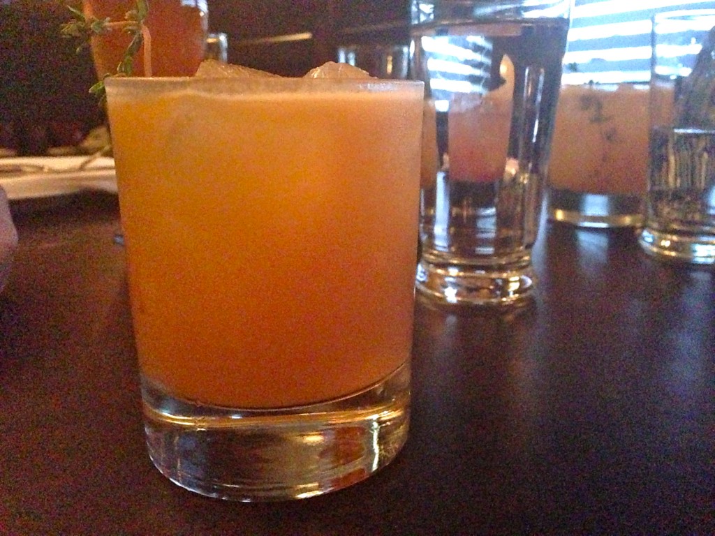 "Loyal Judith" with a sprig of Thyme, gin, orange, lime and chai