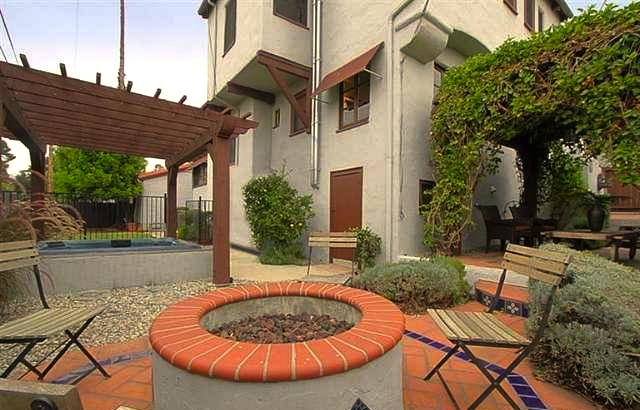 Backyard with built-in fire pit, hot tub and pergola-flanked patio